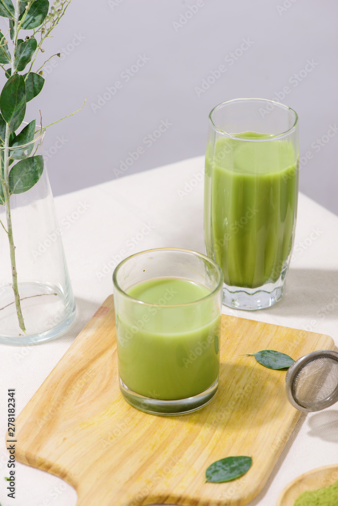 Two green tea glasses on white table. Still life drink Two green tea glasses on white table. Still life drink