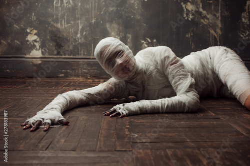 Fotografia Scary mummy creeps on you. The girl with the bandage on the floor