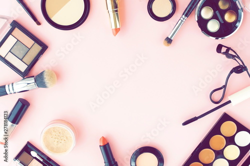 Makeup products, decorative cosmetics on pink background flat lay toned. Fashion and beauty concept. Top view. Copy space.