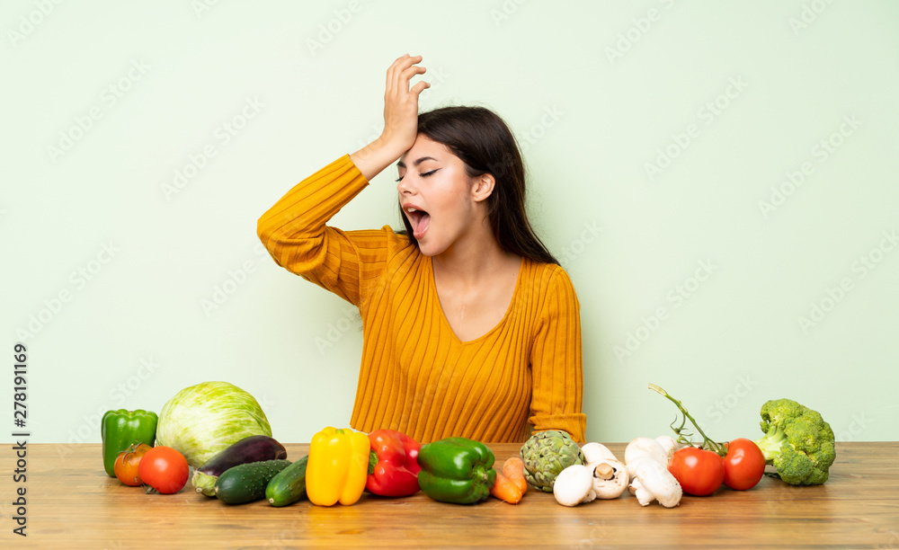 Fototapeta premium Teenager girl with many vegetables has realized something and intending the solution