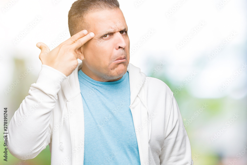 Middle age arab man wearing sweatshirt over isolated background Shooting and killing oneself pointing hand and fingers to head, suicide gesture. Middle age arab man wearing sweatshirt over isolated background Shooting and killing oneself pointing hand and fingers to head, suicide gesture.