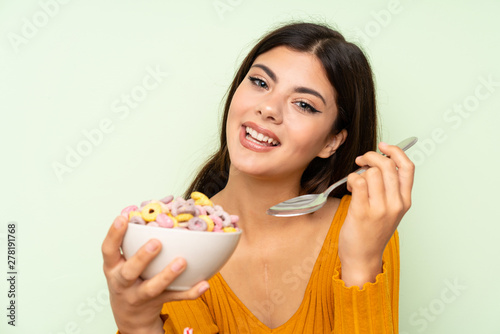 Happy Teenager girl having breakfast with bowl of cereals