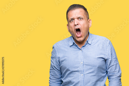 Middle age arab business man over isolated background In shock face, looking skeptical and sarcastic, surprised with open mouth