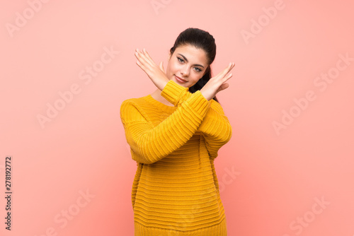 Teenager girl  over isolated pink wall making NO gesture