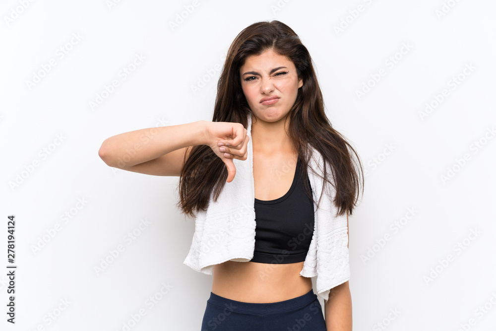 Teenager sport girl over isolated white background showing thumb down sign Teenager sport girl over isolated white background showing thumb down sign