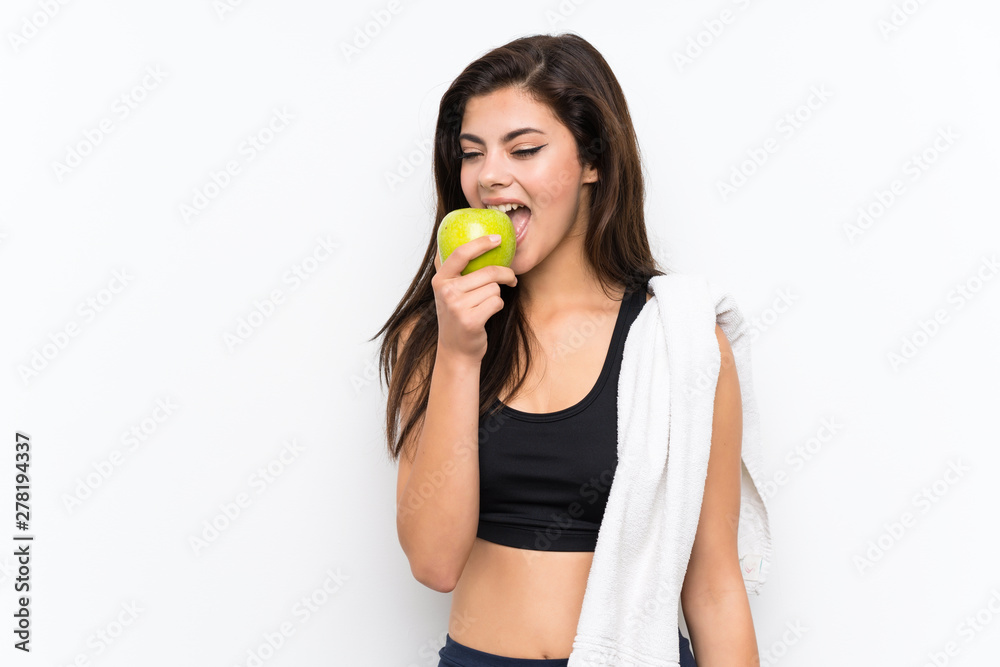 Teenager sport girl over isolated white background with an apple Teenager sport girl over isolated white background with an apple