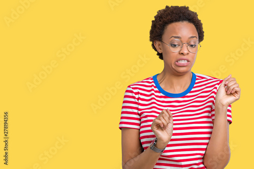 Fotografie, Obraz Beautiful young african american woman wearing glasses over isolated background disgusted expression, displeased and fearful doing disgust face because aversion reaction