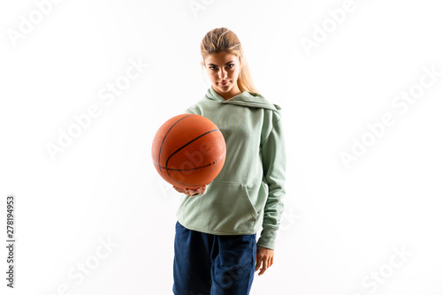 Teenager girl playing basketball over isolated white background