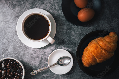 Coffee, white cup and coffee beans, black stone background, top view