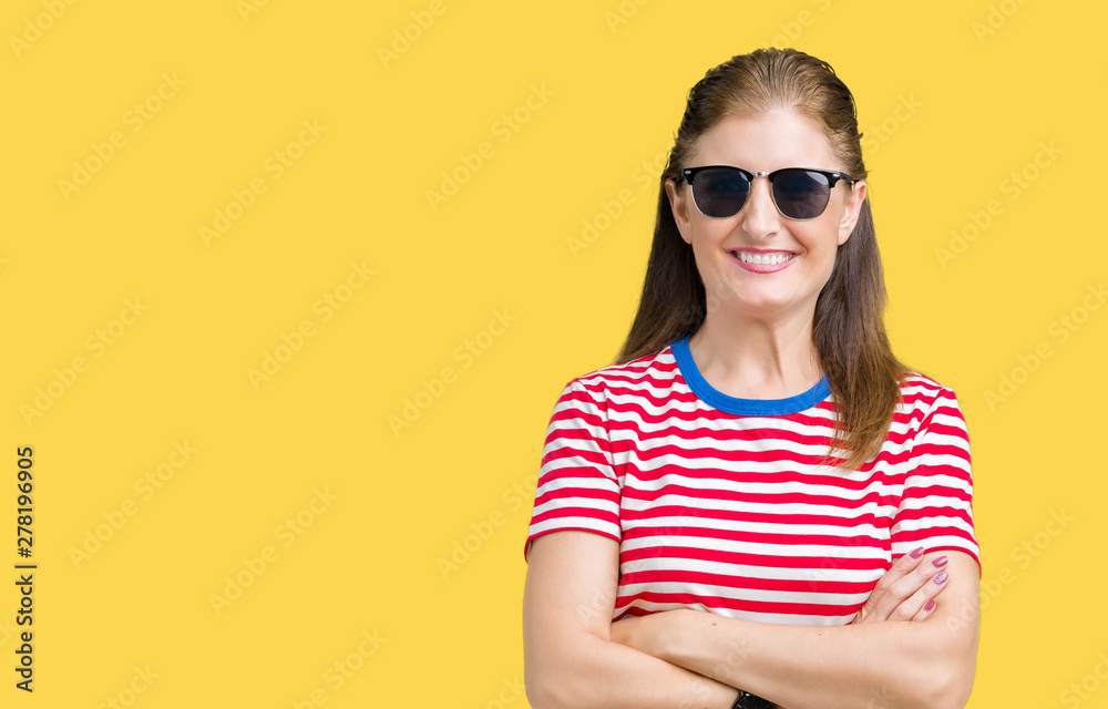 Middle age mature woman wearing sunglasses over isolated background happy face smiling with crossed arms looking at the camera. Positive person. Middle age mature woman wearing sunglasses over isolated background happy face smiling with crossed arms looking at the camera. Positive person.