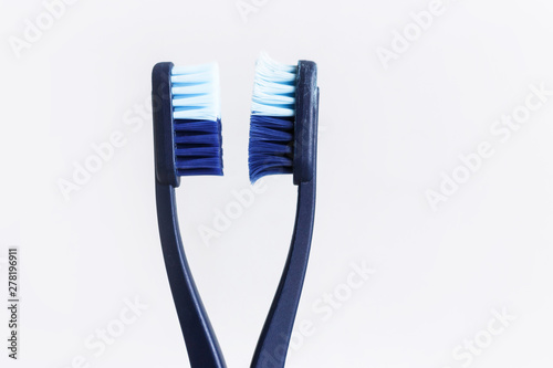 New and used blue color toothbrush in cup on white