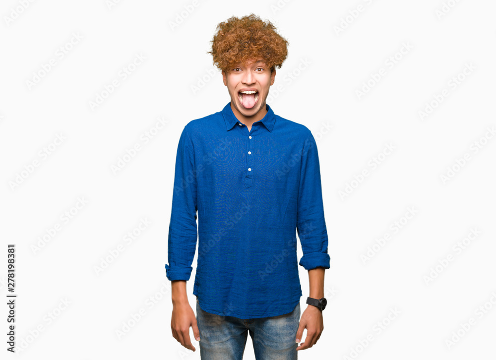 Young handsome elegant man with afro hair sticking tongue out happy with funny expression. Emotion concept. Young handsome elegant man with afro hair sticking tongue out happy with funny expression. Emotion concept.
