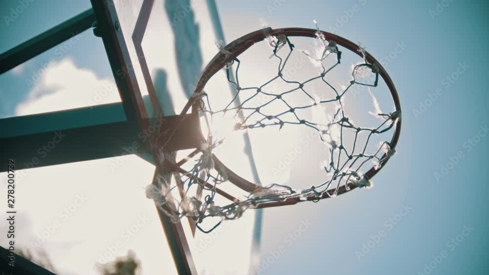 A basketball hoop. The net fluttering in the wind. Bright sunlight A basketball hoop. The net fluttering in the wind. Bright sunlight