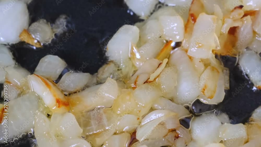 White onion chopped into small pieces stewed with red fresh tomatoes with olive oil on a non-stick teflon griddle, video clip close-up shooting using zoom and camera movement White onion chopped into small pieces stewed with red fresh tomatoes with olive oil on a non-stick teflon griddle, video clip close-up shooting using zoom and camera movement