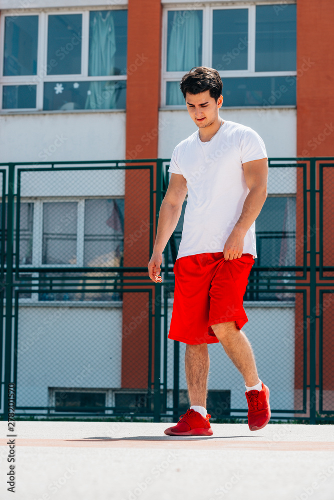 A young man wearing red sneakers on the field Stock Photo | Adobe Stock