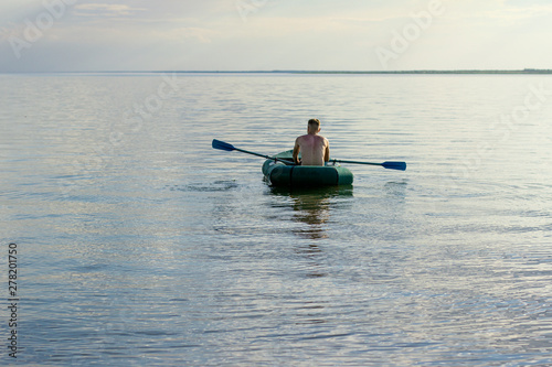  young man sailing on a lake in a boat