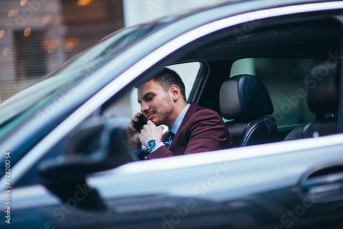 A manager sitting in his limo and discussing and planning his business movies, while applying a lot of body language in his conversation. © qunica.com
