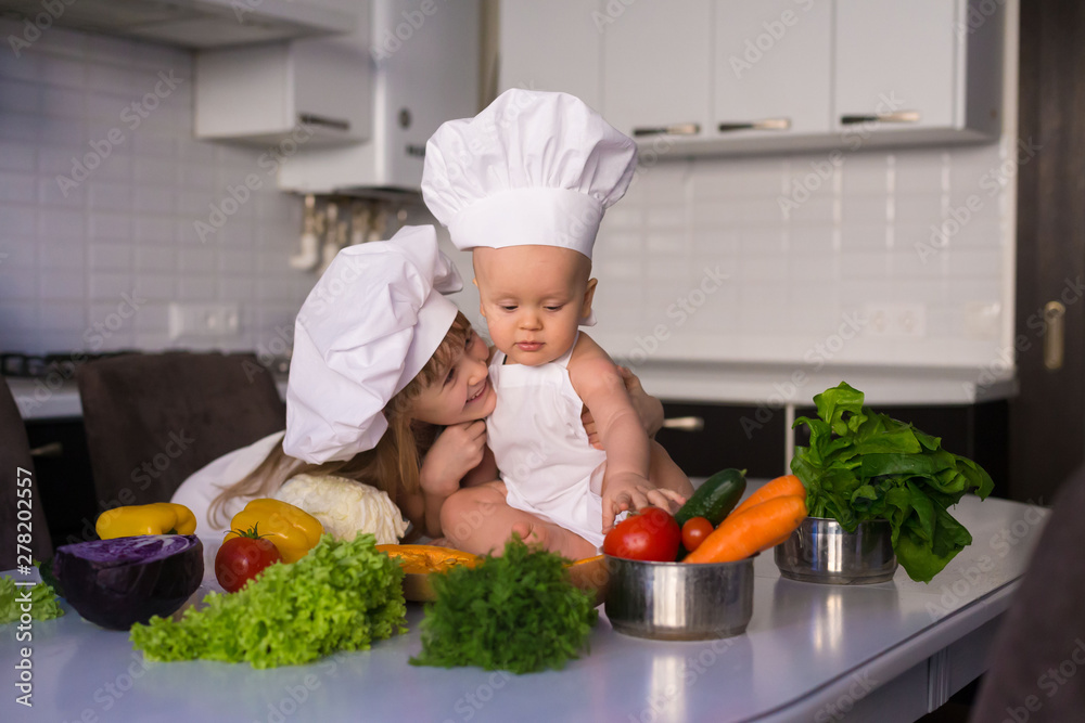 little girl and boy, white chef hat, vegetables little girl and boy, white chef hat, vegetables