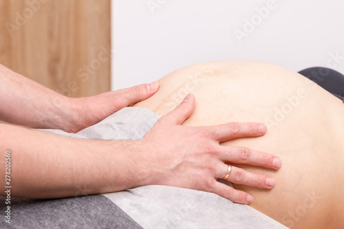 Pregnant woman receiving osteopathic treatment of her belly