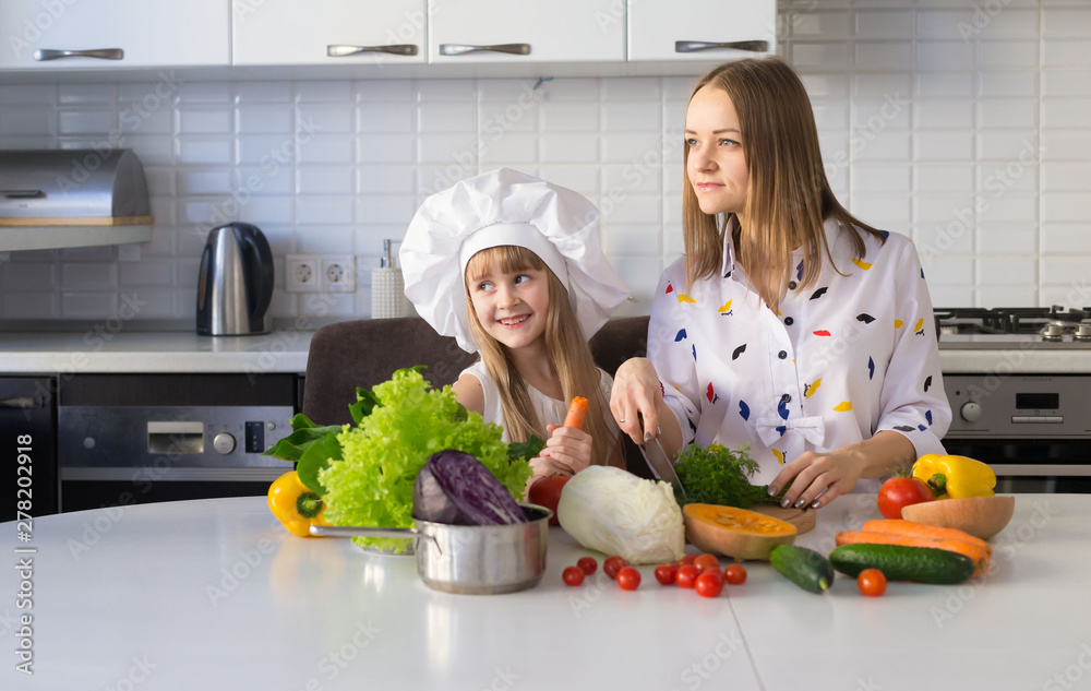 Mother and daughter, white chef hat, vegetables Mother and daughter, white chef hat, vegetables