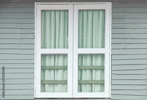 White window doors on old gray wooden houses. © adisorn123