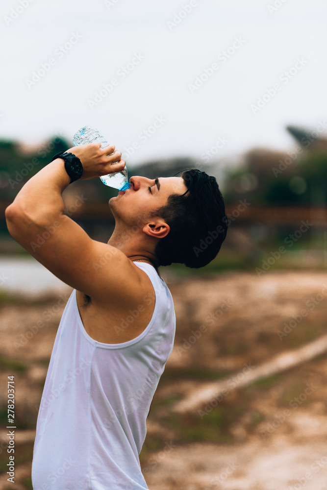 Man drinking water from sportive water bottle Man drinking water from sportive water bottle