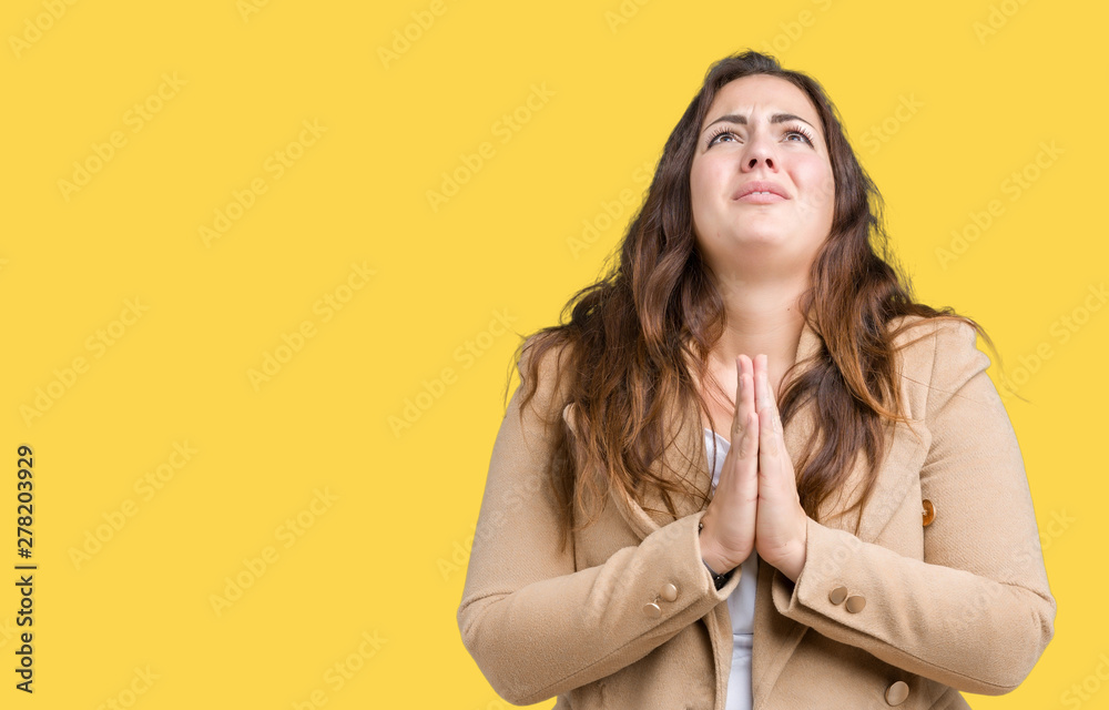 Beautiful plus size young woman wearing winter coat over isolated background begging and praying with hands together with hope expression on face very emotional and worried. Asking for forgiveness. Beautiful plus size young woman wearing winter coat over isolated background begging and praying with hands together with hope expression on face very emotional and worried. Asking for forgiveness.
