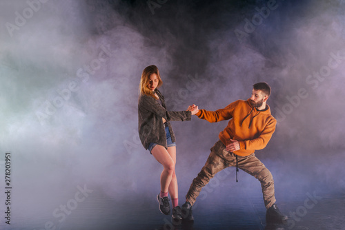 Young couple dancing on the dark background