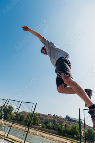 Young man doing tricks while jump in the air