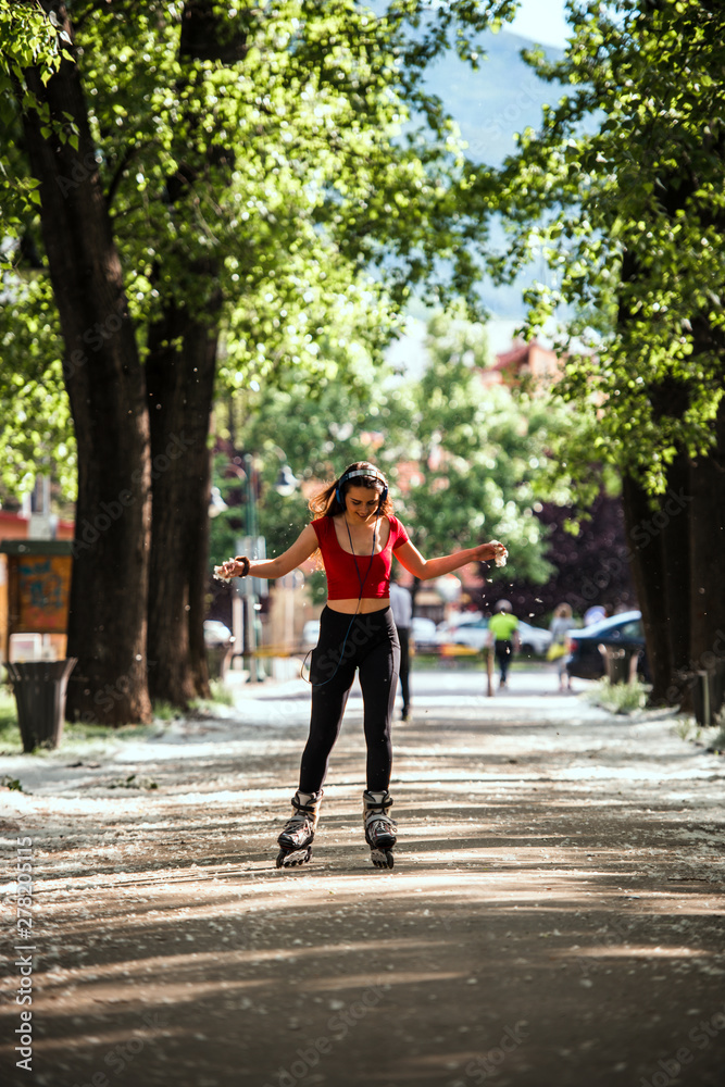 Girl rollerblading with headphones active lifestyle on inline skates