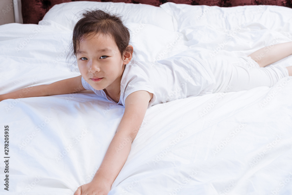 Chinese girls in white clothes lying on the bed playing Chinese girls in white clothes lying on the bed playing