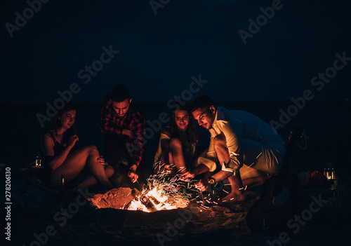 Photography Friends were sitting around the fire while drinking beer and playing guitar