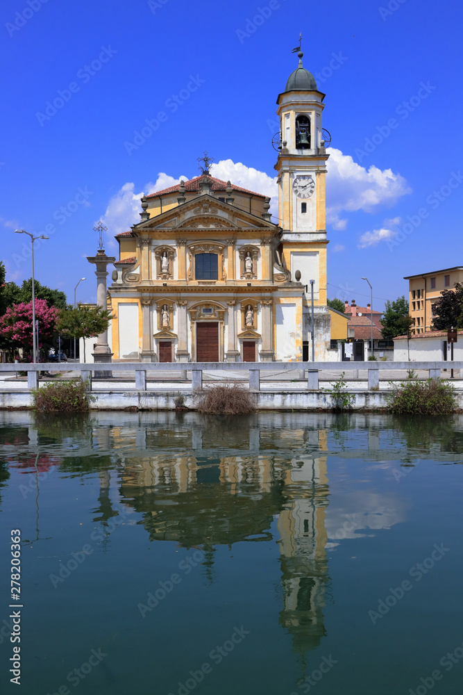 chiesa e cmpanile con riflessi sul fiume a gaggiano in italia, 