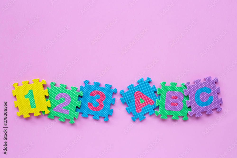 Alphabet puzzle with number puzzle on pink background. Alphabet puzzle with number puzzle on pink background.