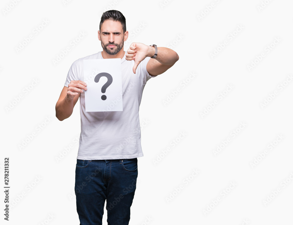 Handsome young man holding paper with question mark over isolated background with angry face, negative sign showing dislike with thumbs down, rejection concept Handsome young man holding paper with question mark over isolated background with angry face, negative sign showing dislike with thumbs down, rejection concept