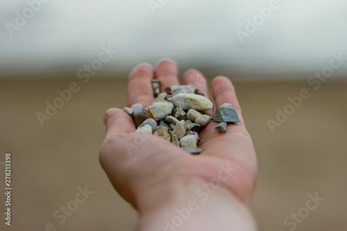 a handful of sea pebbles in hand