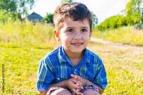 cheerful brown-eyed boy outdoors in summer