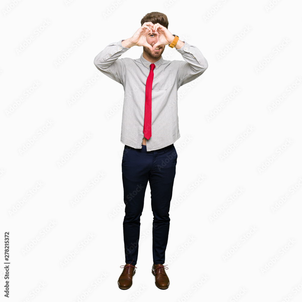 Young handsome business man Doing heart shape with hand and fingers smiling looking through sign Young handsome business man Doing heart shape with hand and fingers smiling looking through sign