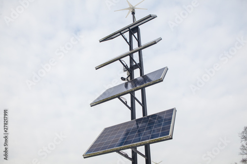 Ecology Power Conservation Concept. Solar station stands in a park on a winter cloudy day. Solar Panels Farm (solar cell) with sunlight.