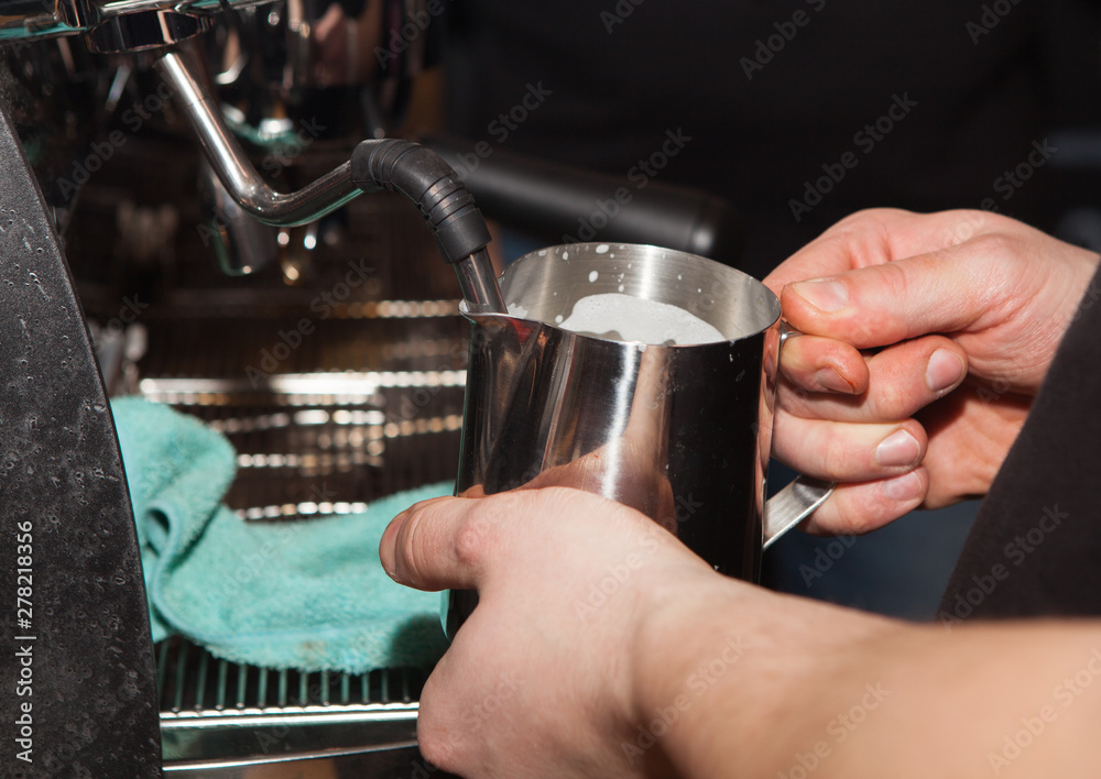 Close-up of a barista eating milk in coffee. Barista makes coffee for customers.