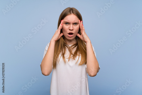 Young woman over blue wall with surprise and shocked facial expression