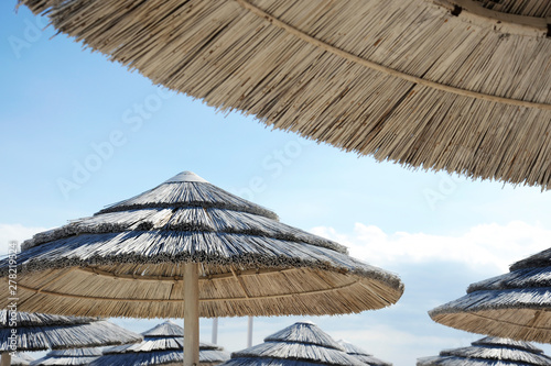 Beautiful beach resort with white straw umbrellas on a blue sky and white clouds. Beach life and lifestyle concept. Torre Lapillo  Salento  Apulia  Italy