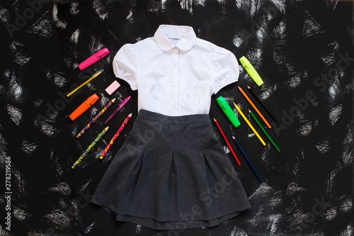 School uniform and stetionery on the black background. Back to school concept. photo