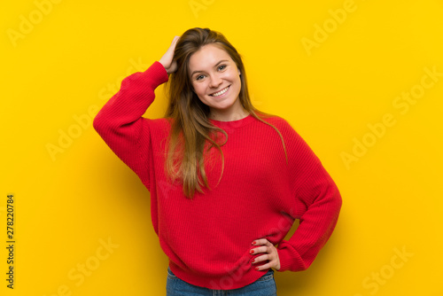 Young woman over yellow wall laughing