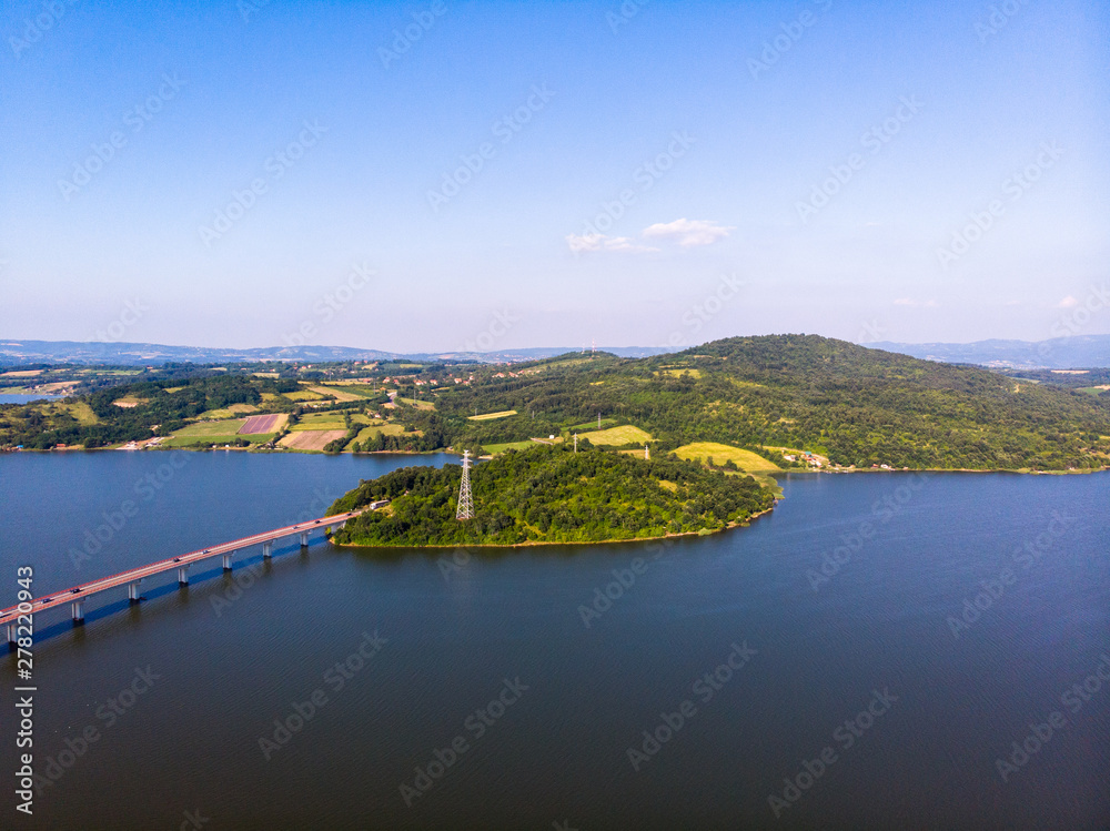 Fototapeta premium Aerial view of lake, forest and agriculture field by the water, at summer. Gruza lake near the Kragujevac in Serbia.