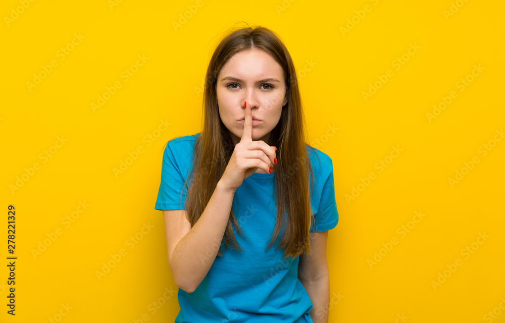 Young woman with blue shirt doing silence gesture Young woman with blue shirt doing silence gesture