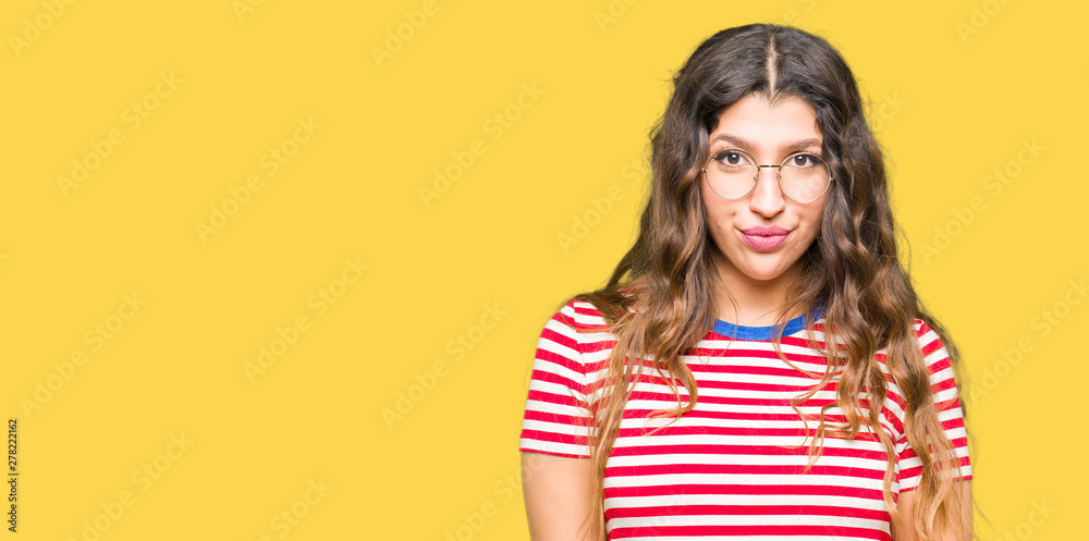 Young beautiful woman wearing glasses Hands together and fingers crossed smiling relaxed and cheerful. Success and optimistic Young beautiful woman wearing glasses Hands together and fingers crossed smiling relaxed and cheerful. Success and optimistic