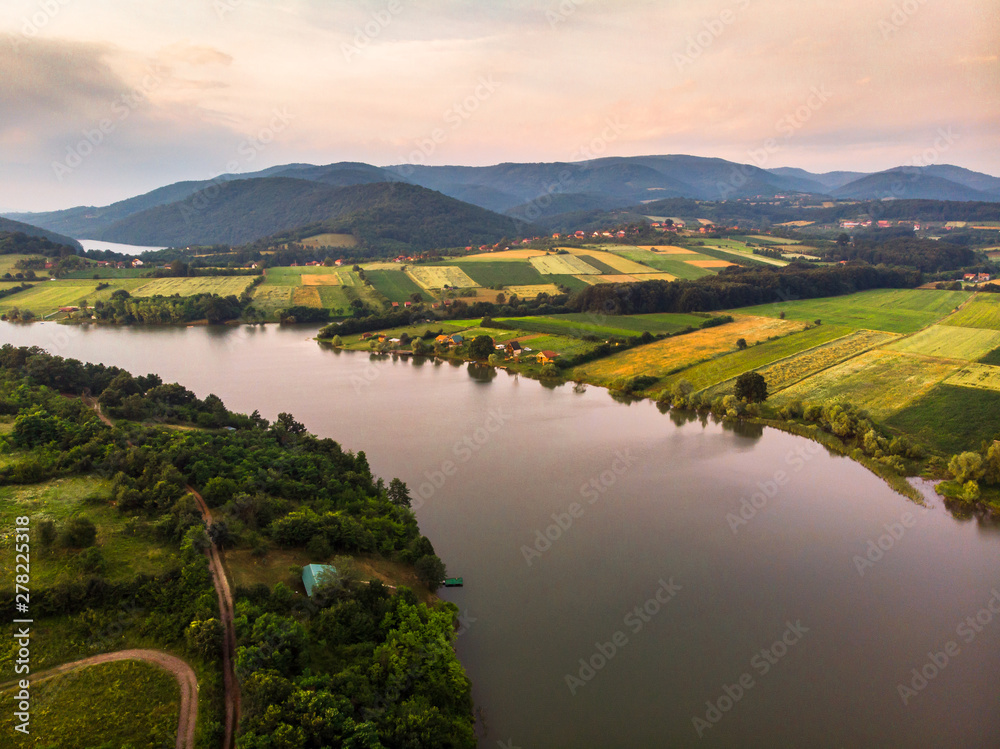 Aerial view of lake, forest and agriculture field by the water, at summer. Gruza lake near the Kragujevac in Serbia.