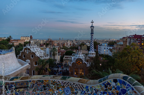 View of Barcelona from Park Guell at the sunset. In the foreground the colourful buildings of the main entrance. Barcelona.
