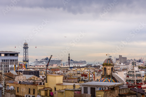 View of the roofs of Barri Gotic from the Cathedral terrace. The harbor in the background. Barcelona.